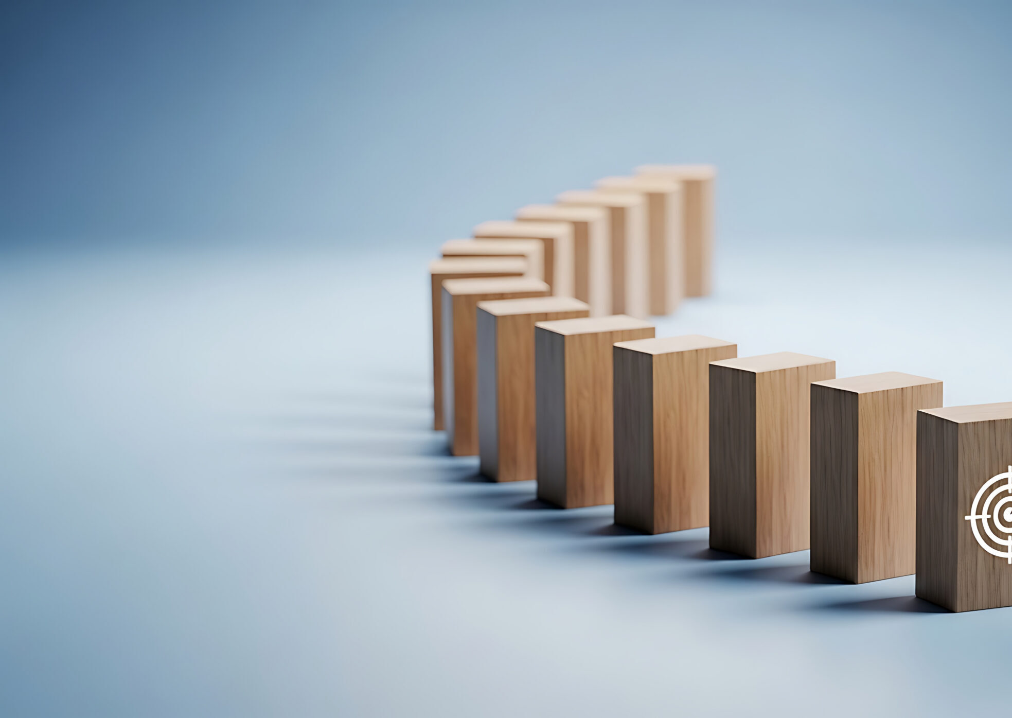 A row of wooden blocks lined up like dominos, against a light blue background